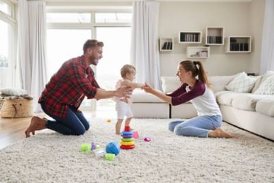 Parents playing with baby in living room