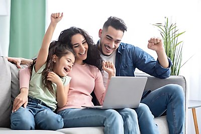 Family on couch looking at laptop