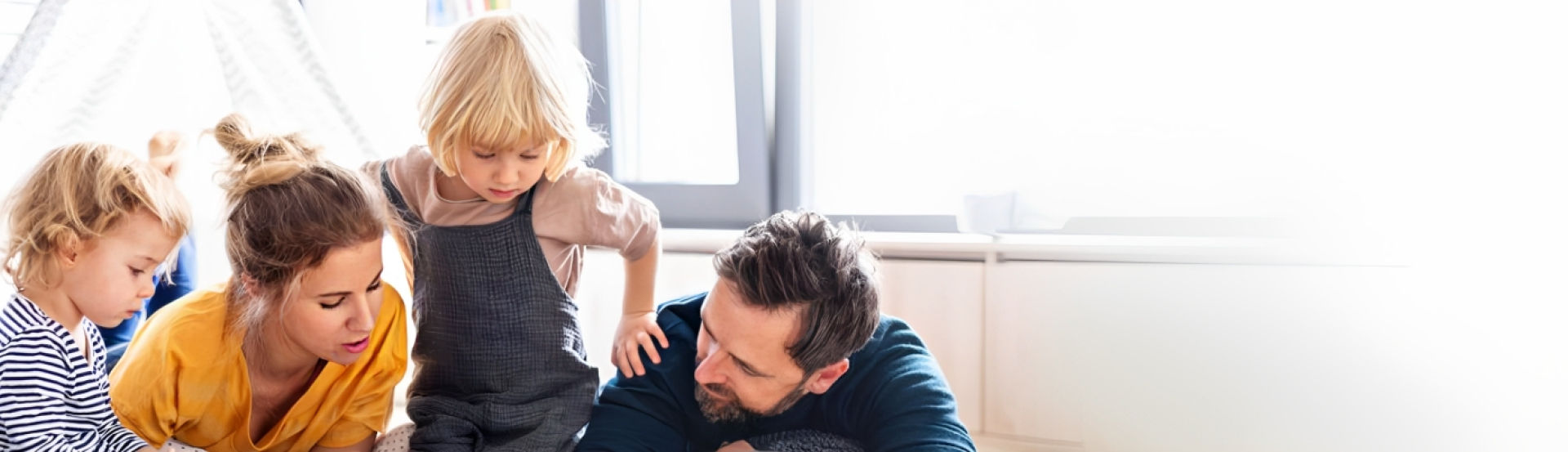 Mother reading with her children and husband