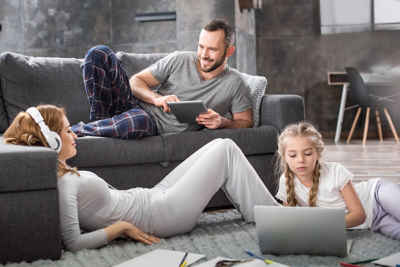 Family lounging and using electronic devices