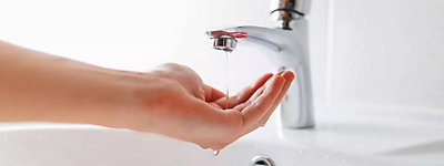 Hand under faucet with low pressure water stream - Jarboe's Plumbing, Heating, and Cooling