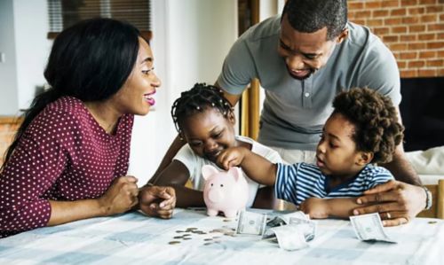 A family putting money into a piggy bank