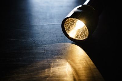 Flashlight laying on a dark floor
