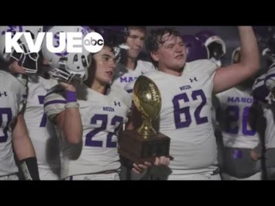 A group of football players holding a trophy.