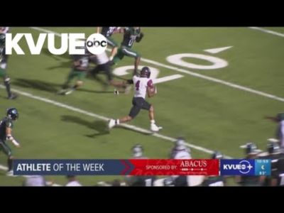 Football player Justin Cannon running the ball across the field.