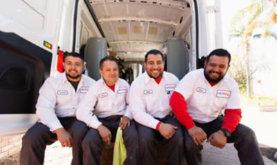 Four Techs sitting in the back of an open truck