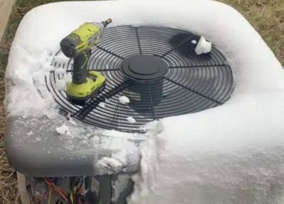 A condenser covered in frost with an electric drill on top