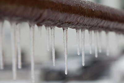Close up of pipe frozen with ice cycles