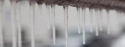 Icicles hanging from a brown pipe