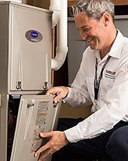 Technician installing furnace and smiling