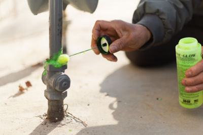 Technician putting a solution on gas pipes to test for leaks