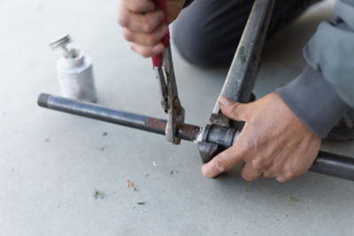 Technician tightening up gas pipes on the ground