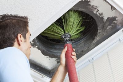 Man-cleaning-air-ducts-in-home-HVAC-system