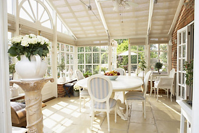 A bright sunny screened in porch with potted plants