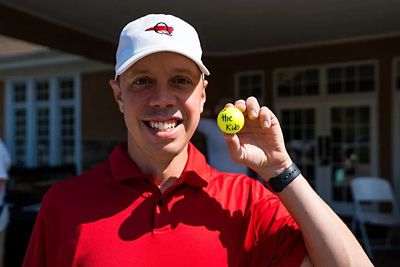 Smiling golfer holding a golf ball at the Levine children's hospital fundraiser