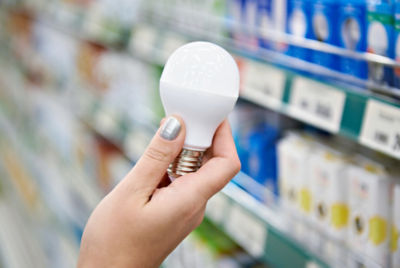 Hand holding up an LED lightbulb in store