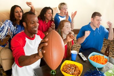 Happy, comfortable people watching football in the living room