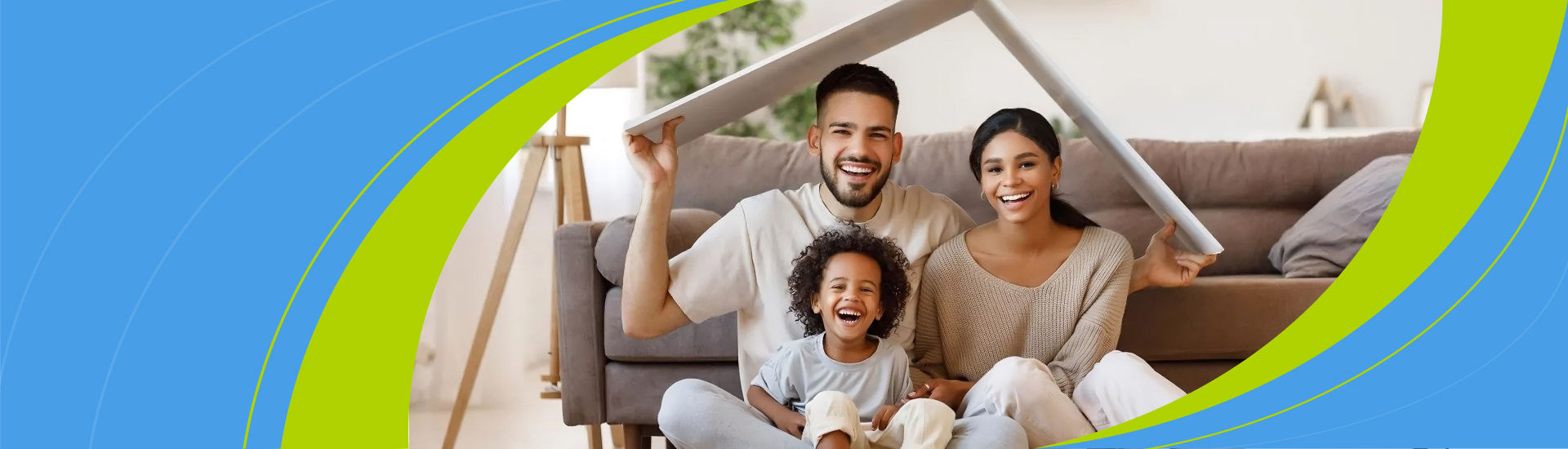 A couple sitting on the floor with a child under a cardboard roof