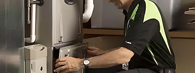 Technician repairing a furnace - Williams Comfort Air Heating, Cooling, Plumbing & More