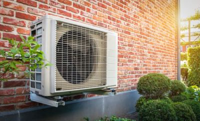 Image of a mounted heat pump on a brick wall