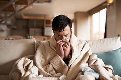 man at home feeling sick on his couch