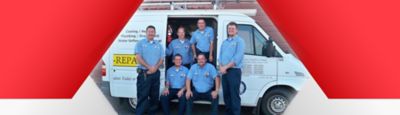 Technician smiling in front of his van
