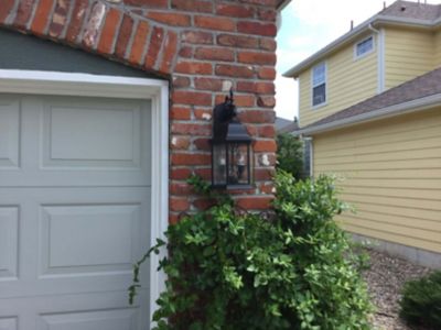 Coach light fixture on brick by garage door