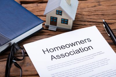 Homeowners Assocation document with a house, books and pen in the background