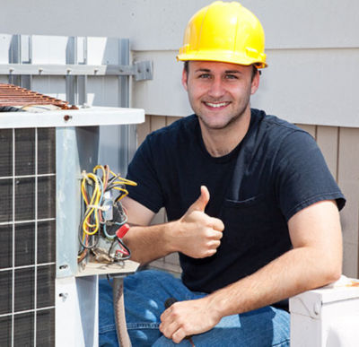 HVAC Tech next to AC condenser unit giving thumbs up