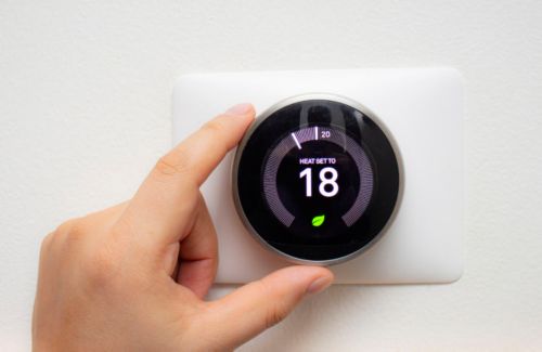 A hand holding a thermostat