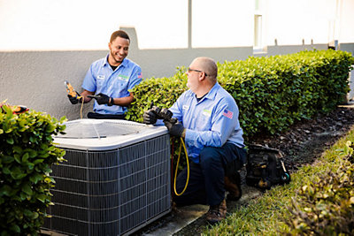 Cool Today AC technicians repairing an air conditioner at a Palm Harbor home