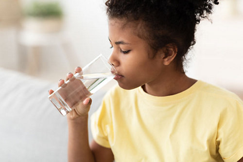 a child drinking water from a glass