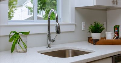 Pretty modern kitchen with white countertops. This kitchen has been treated to prevent drain flies.