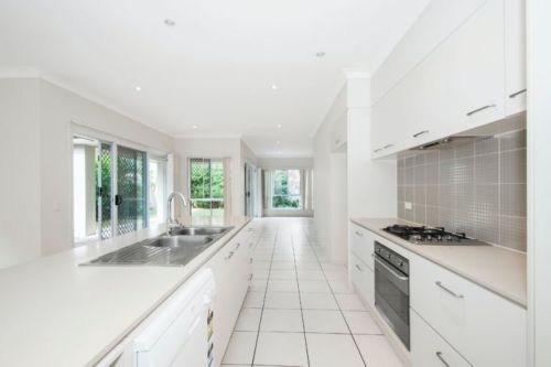 A kitchen with white cabinets and appliances