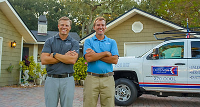 HVAC technicans from Donovan smiling in driveway of a Jacksonville Beach home