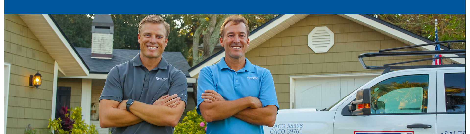 Two technicians smiling in driveway