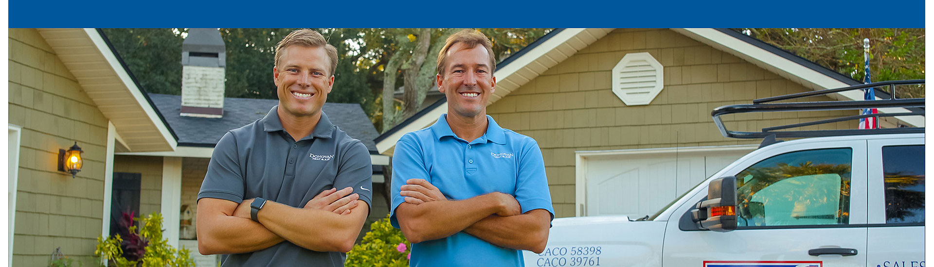 Two technicians smiling in driveway