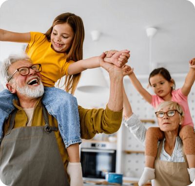 Grandparents playing with grandchildren on their shoulders