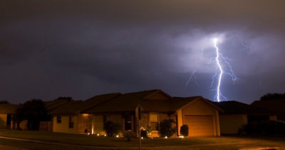 Lightning strikes near houses at night