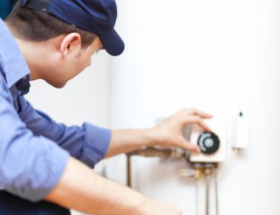 Plumber adjusting water heater gauge