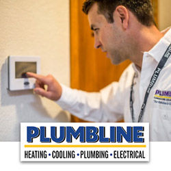 HVAC tech from Plumbline adjusting a thermostat