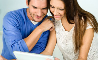 Man and woman affectionately looking at laptop together