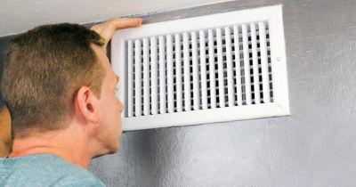 Man inspecting air vent