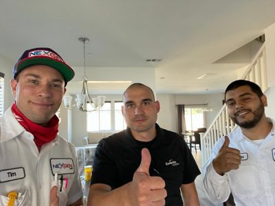 2 NexGen Techs Posing with a customer in his home