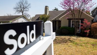 Ooutside of a house with a sold signn in front of it