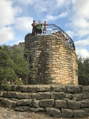 Family standing at the top of a brick wall at Mother Neff State Park