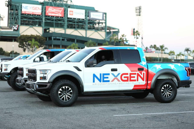 A NexGen work truck parked in front of a stadium.