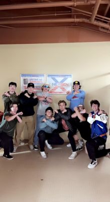 Group of nine men making an x with their arms