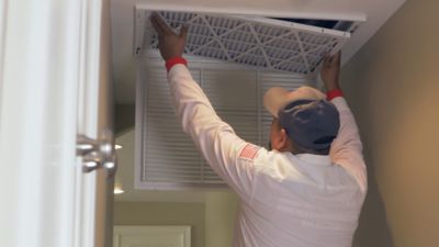 A NexGen employee installing an air filter.