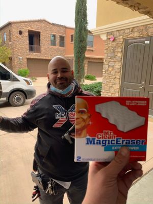 Bald technican standing behind a mr. clean magic eraser box